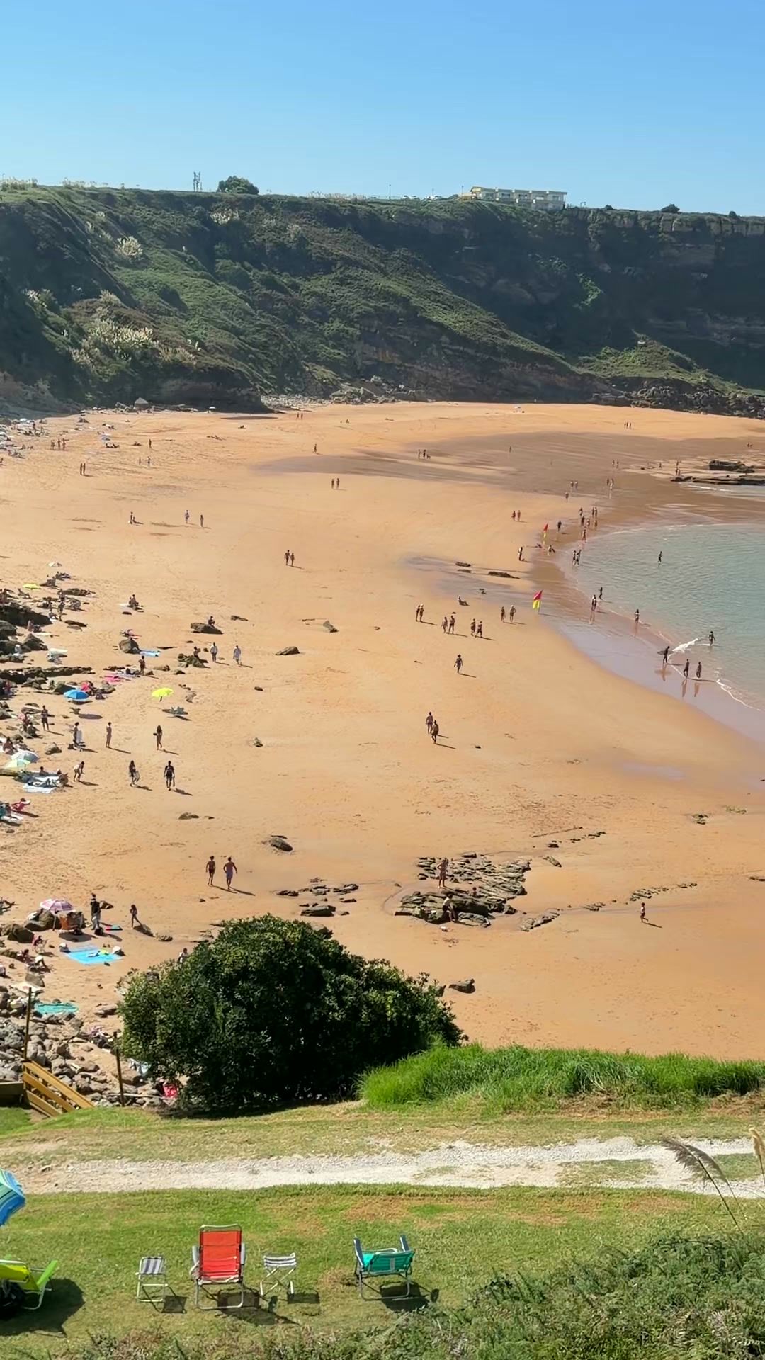 Vista desde el acantilado de la Playa de los Locos, con la pradera arriba y la arena dorada